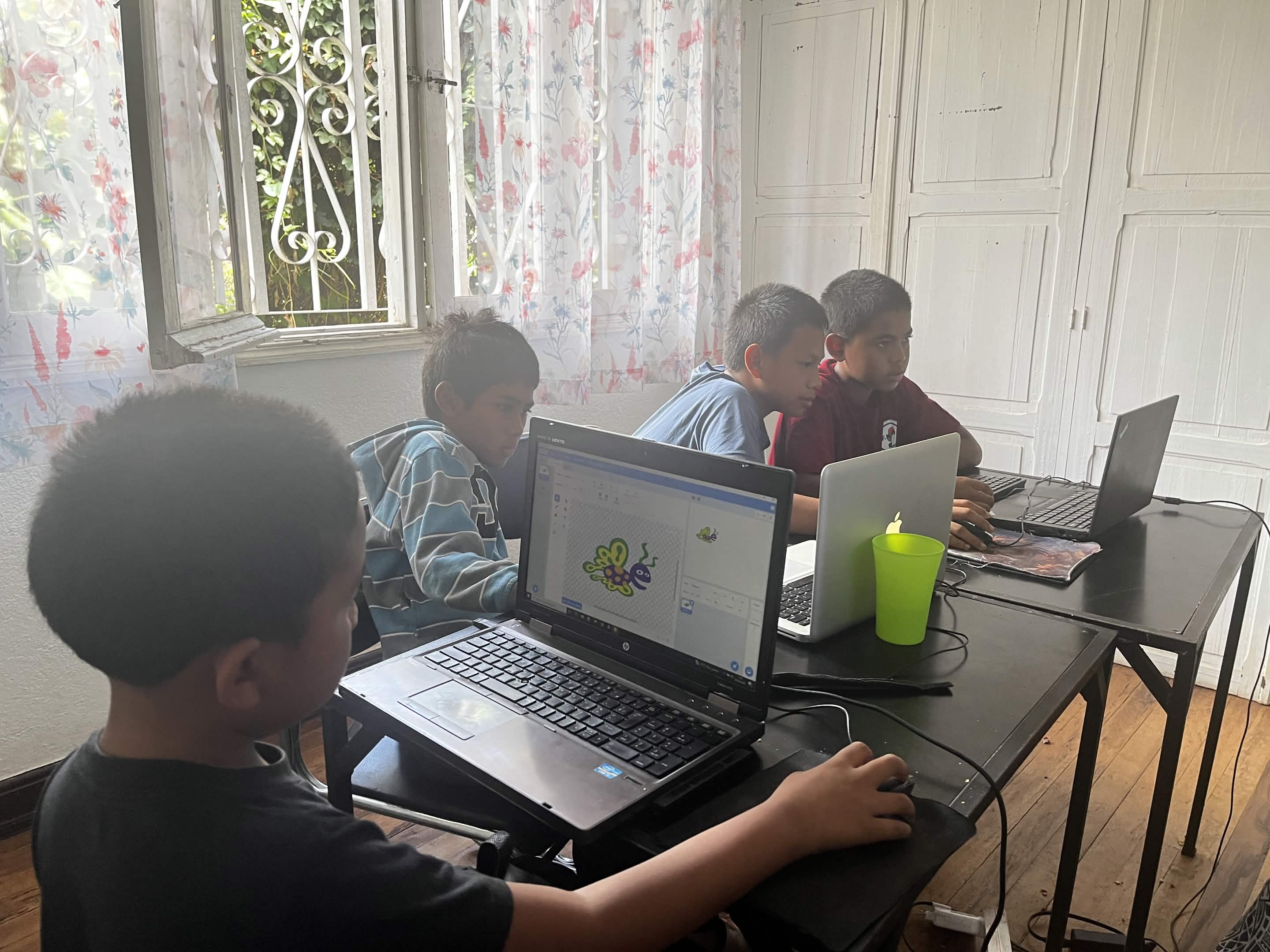 Groupe d'enfants souriants avec un robot et une tablette